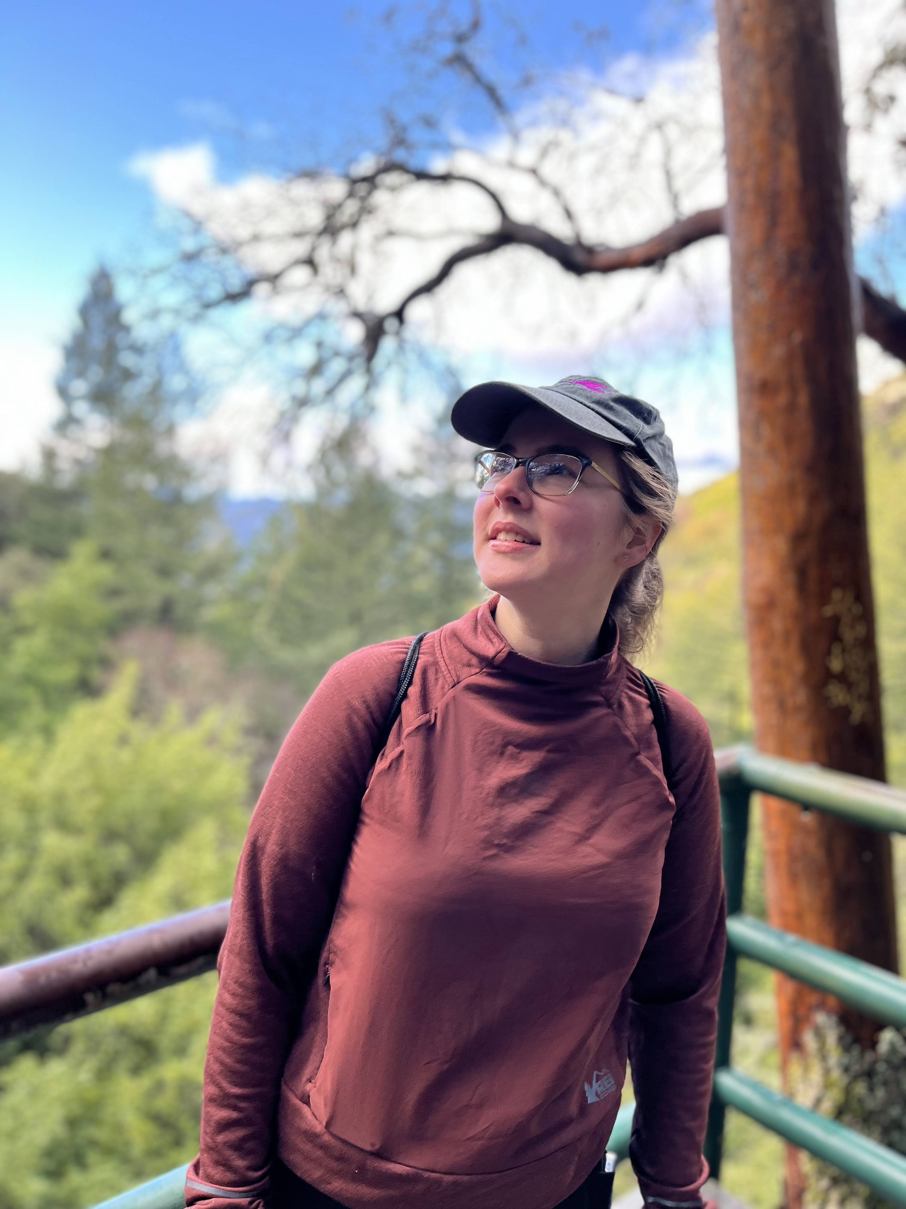 woman standing at vista point looking up at the trees